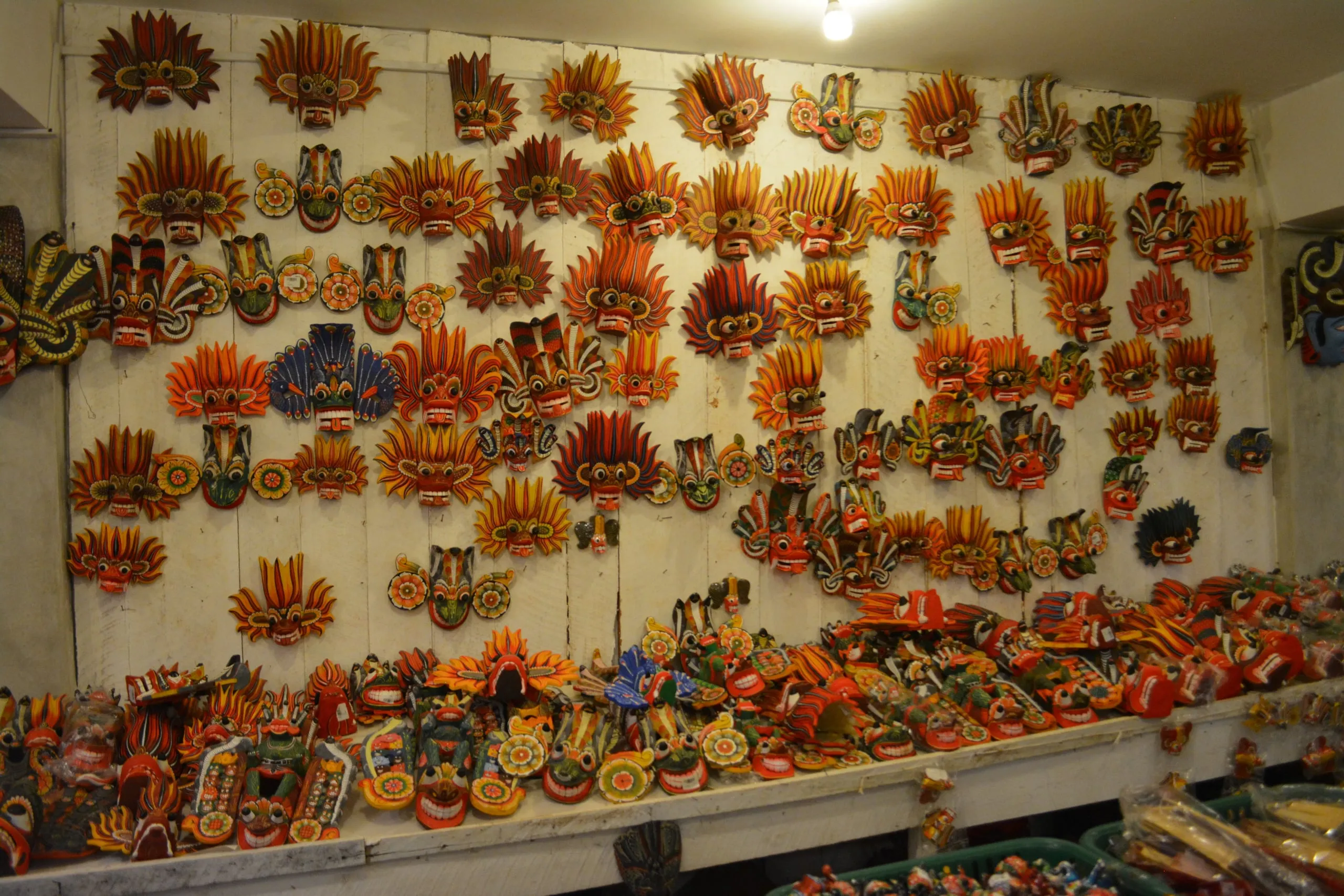 A wall of hand-carved and painted masks at a carving workshop